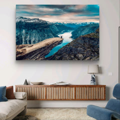 A man sits and throws his arms in the air, Trolltunga | Mural