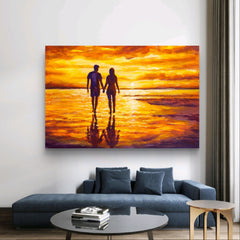 Lovers walking along the ocean shore at sunset