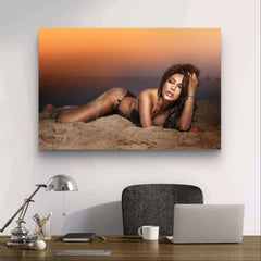Elegante Dame mit perfektem Körper liegt während des Sonnenuntergangs am Strand